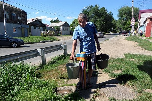 люди ходят за водой в колонку