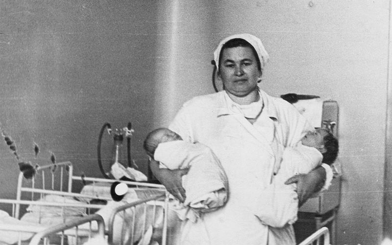 фото моей бабушки  - медсестры детской комнаты с парой подопечных на руках